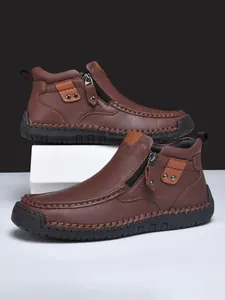 Dettaglio di stivaletti casual in pelle marrone con cuciture a mano e zip laterale