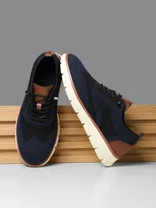 Detail of navy knit mesh upper with brown leather accents and lightweight EVA sole
