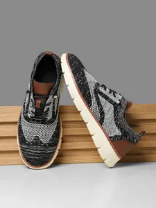 Detail of men's knit sneakers with mixed grey texture and premium brown leather accents