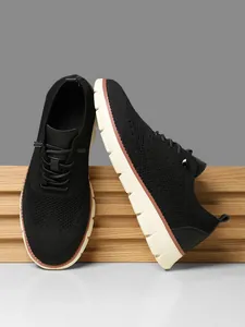 Detail view of black knitted breathable upper and thick non-slip sole on men's sneaker