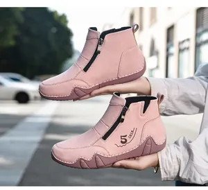 Detail of pink suede ankle boots featuring side zipper and non-slip rubber soles