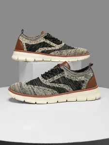 Detail of breathable knitted mesh sneakers for men featuring beige and black geometric patterns