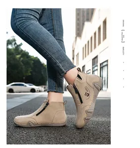 Detail of khaki suede boots with side zipper and vintage print worn with denim jeans