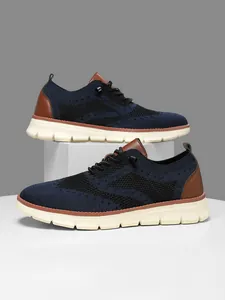 Macro shot of breathable fly-knit texture and brown leather details on men's blue sneakers
