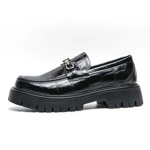Dettaglio di mocassini neri con motivo a coccodrillo e suola a carrarmato spessa