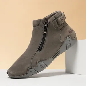 Detalle de botines grises con cremallera lateral y suelas de goma antideslizantes