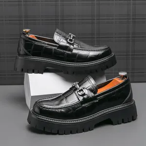 Dettaglio mocassino nero in pelle goffrata coccodrillo con fibbia in metallo e suola platform