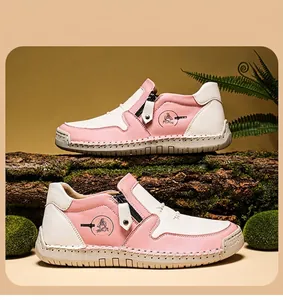 Gros plan de bottines en cuir rose et blanc avec fermeture éclair et semelle cousue main