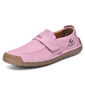 Nahaufnahme von rosa Leder-Loafers mit weißen Handnähten und Klettverschluss für Kinder
