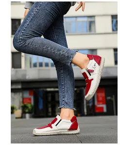 Détail de bottines en cuir rouge et blanc avec fermeture éclair et coutures épaisses