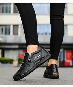 Détail de chaussures décontractées en cuir noir avec coutures et accent orange au talon