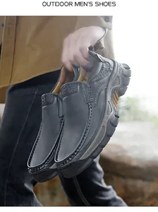 Detailed close-up of dark grey leather outdoor shoes with thick soles and side stitching