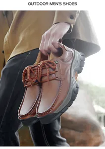 Close-up of durable brown leather outdoor men's shoes with rugged soles and orange details