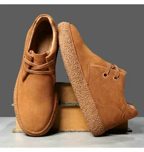Close-up of brown suede men's boots with textured thick rubber sole and retro style