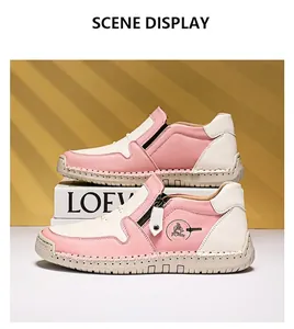 Détail de bottines en cuir rose et blanc avec fermeture éclair et coutures à la main