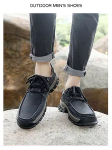 Outdoor men's casual shoes in black leather with thick non-slip soles on rocky terrain