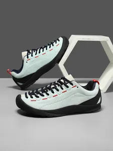 Λεπτομέρεια από μπλε σουέντ sneaker με κόκκινες ραφές και χοντρές σόλες από καουτσούκ
