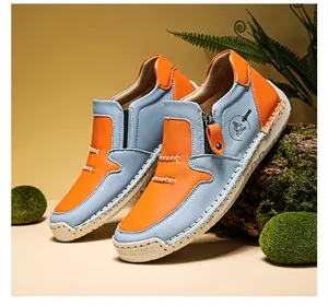 Vue détaillée des bottines en cuir bleu et orange avec fermeture éclair et semelle en gomme