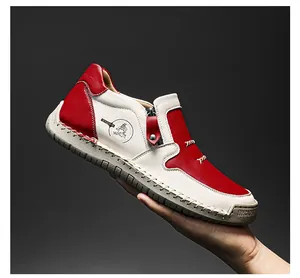 Détail de bottine en cuir rouge et blanc avec fermeture éclair et coutures à la main