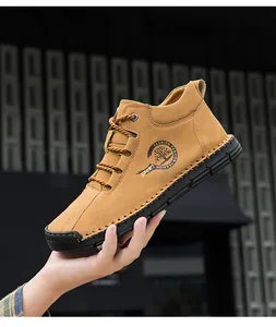Detail of khaki suede casual mid-top boot with round logo and hand-stitched sole