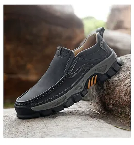 Detail of dark grey leather outdoor shoe showing orange anti-slip sole and hand-stitched seams