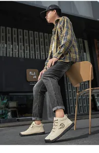 Men's casual beige boots styled with plaid shirt and washed jeans in urban setting