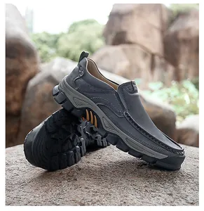 Detail of dark grey leather outdoor shoes featuring thick non-slip rubber soles on rocks