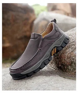Macro view of brown leather slip-on shoe with rugged rubber sole on rocky terrain