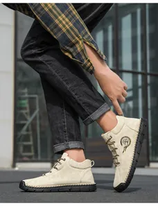 Close-up of beige casual leather boots showing fashion logo and thick hand-stitched details