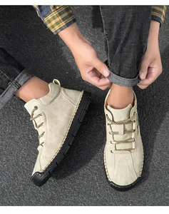 Detail of men's khaki suede boots featuring decorative hand-stitched mocc-toe seams