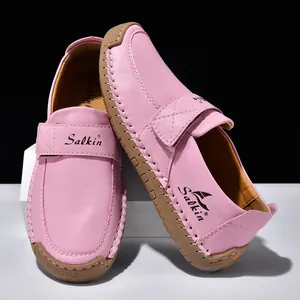 Detail eines rosa Leder-Loafers mit Klettverschluss und Kontrastnaht an der Gummisohle