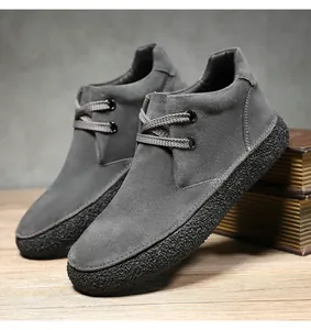 Detail view of dark grey suede leather boots with thick non-slip textured rubber soles