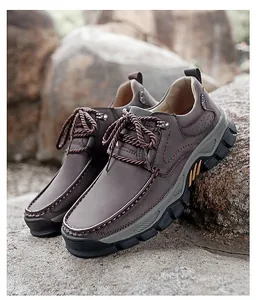 Detail of dark brown leather outdoor shoes with anti-slip rubber soles on rocks
