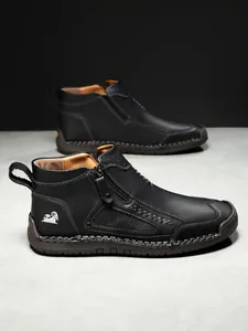 Detailansicht schwarzer Leder-Boots mit seitlichem Reißverschluss und Handnaht-Verarbeitung
