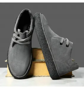 Detail of grey suede casual shoes with thick textured sole on decorative books