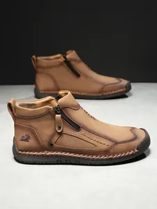 Detailansicht brauner Herrenstiefel aus Leder mit Reißverschluss und Logostickerei