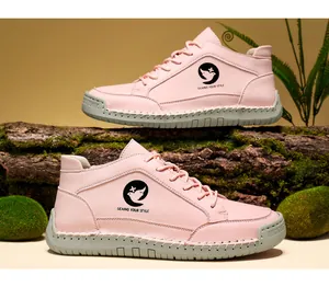 Détail de bottines en cuir rose avec semelles épaisses cousues main et logo latéral
