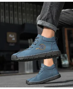 Macro detail of men's blue high-top casual shoe with contrast stitching and rubber toe cap