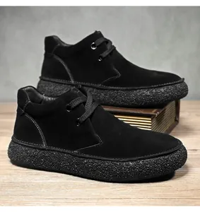 Detailed close-up of men's matte suede mid-top boots with contrast stitching and thick sole