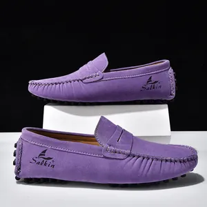 Dettaglio di mocassini in pelle scamosciata viola con cuciture bianche e logo Salkin