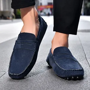 Dettaglio di mocassini in pelle scamosciata blu navy con cuciture a mano e suola a gommini