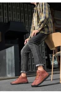 Detail of brown leather men's boot with hand-stitched sole and fashion logo print