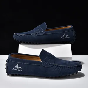 Dettaglio mocassini in pelle scamosciata blu navy con logo bianco e suola gommini