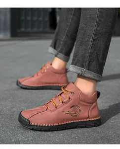 Detail view of brown leather men's high-top casual boots with hand-stitched soles