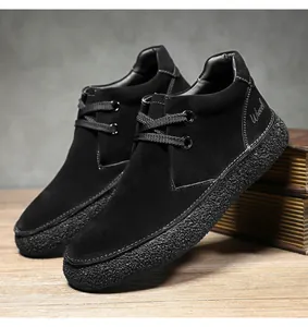 Detail of black suede men's boot with white stitching and textured rubber sole