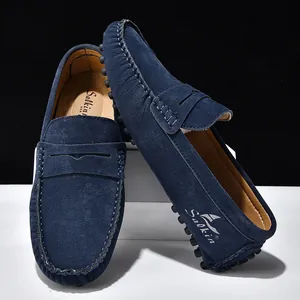 Dettaglio di mocassini in pelle scamosciata blu navy con cuciture e suola a gommini