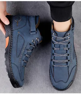 Detail van marineblauwe hoge herenschoenen met zijstiksels en sportlogo in reliëf