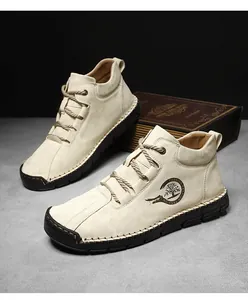 Close-up of hand-stitched seams and beige nubuck upper on outdoor casual boots