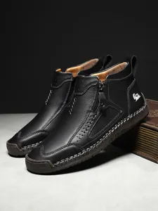 Details von Herren-Stiefeletten aus schwarzem Leder mit Metallreißverschluss und Nähten
