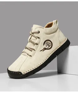 Detail of hand-stitched sole and fashion logo on beige suede high-top casual men's shoes